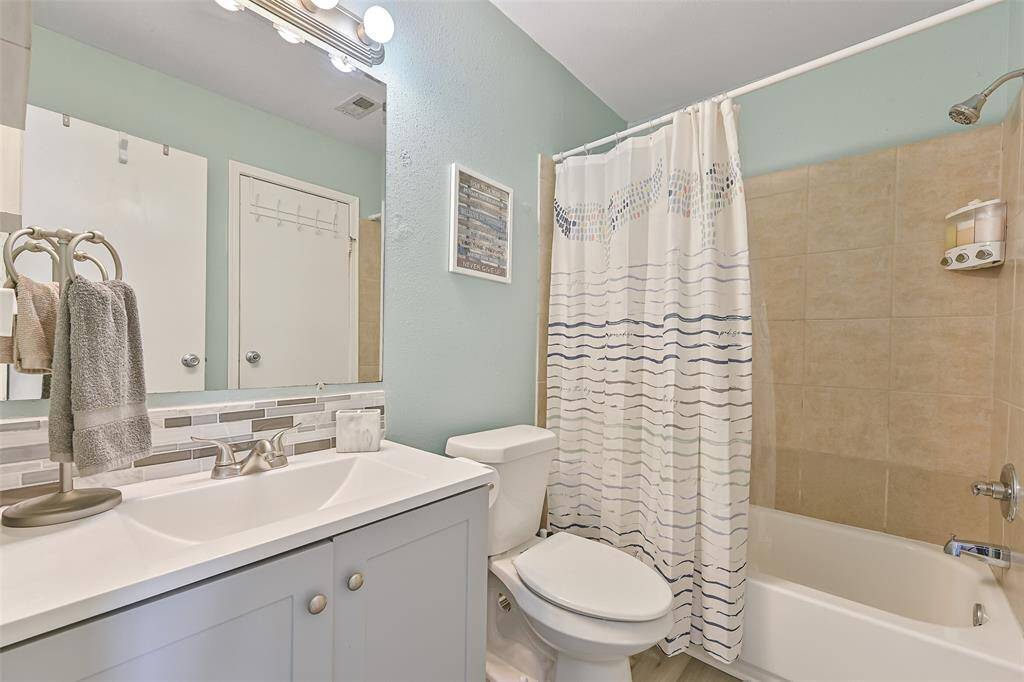 Updated bathroom with a new vanity and modern tiled backsplash. The tub/shower combination provides for versatile bathing options.