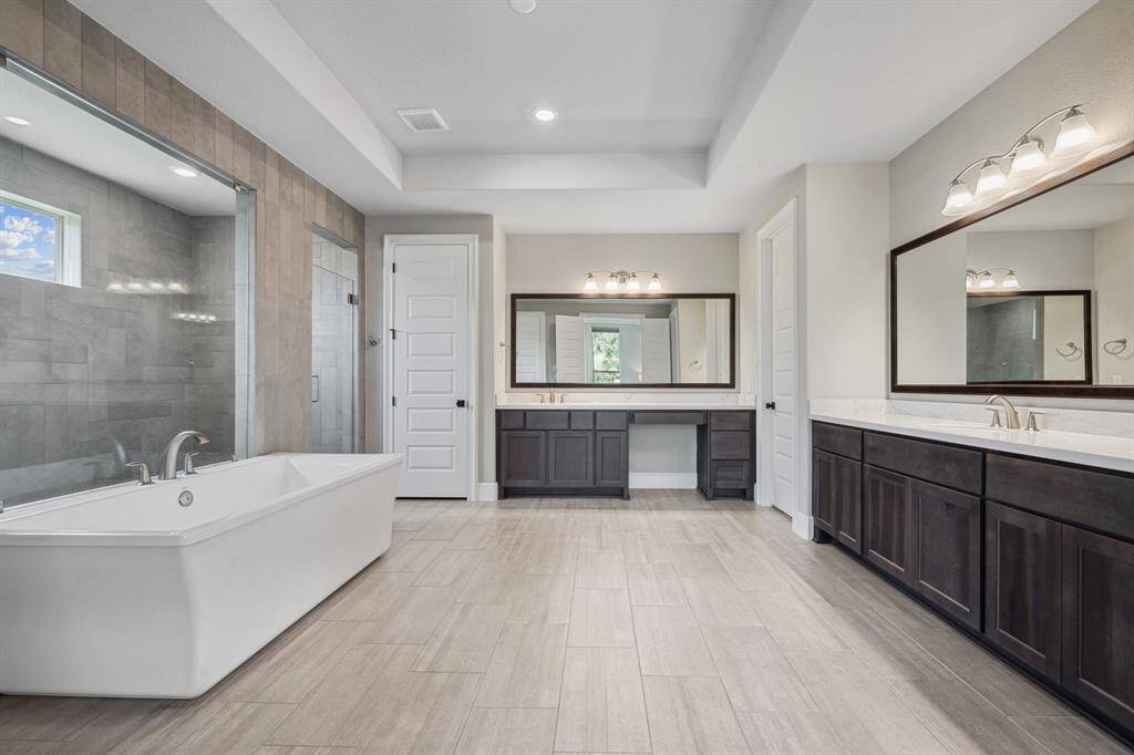 Expansive primary bathroom leads to separate closets.