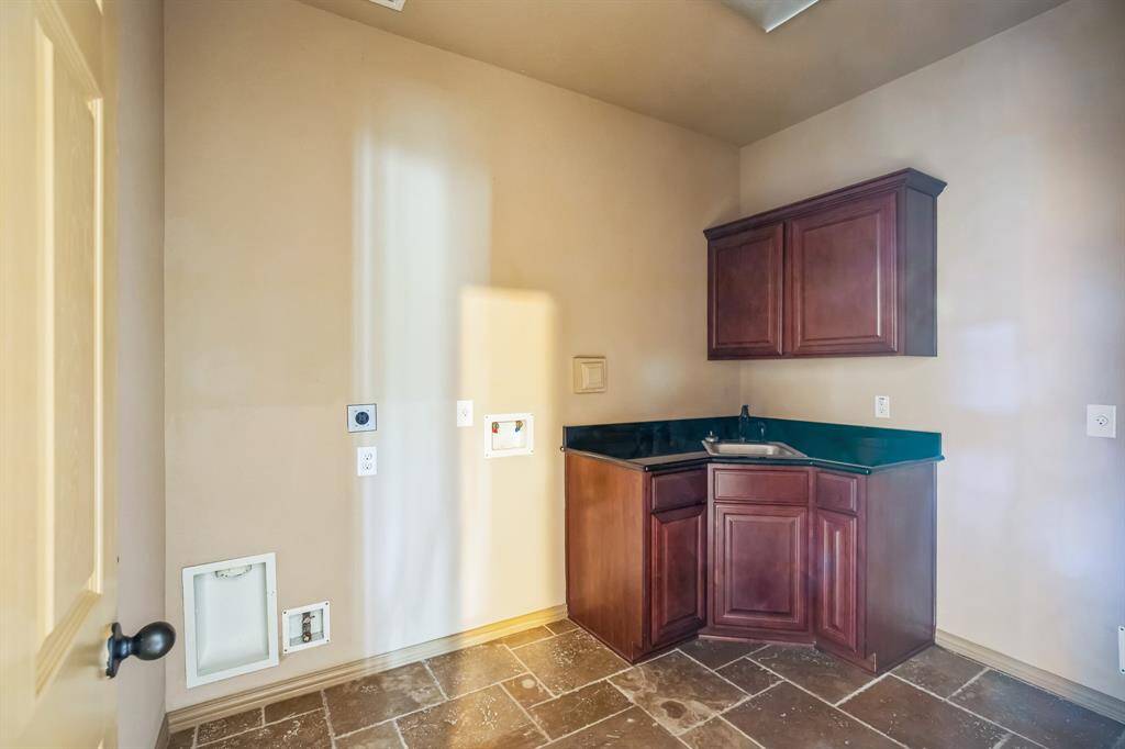 Laundry room with sink and freezer space.