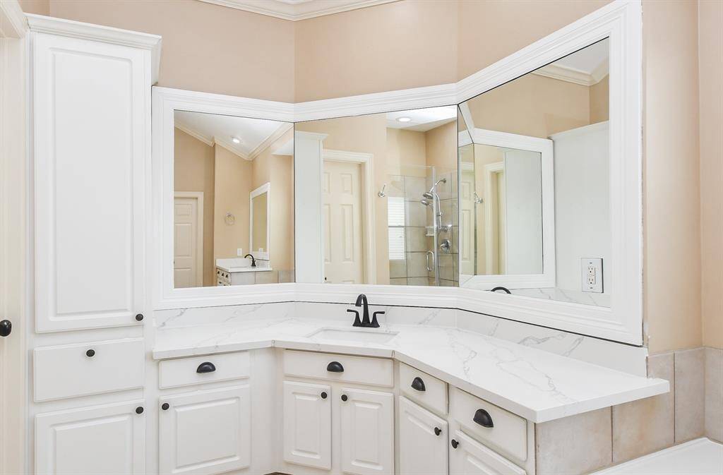 Dual, separate sinks with bay window-like mirrors above, are comfortably placed for your personal rhythms.