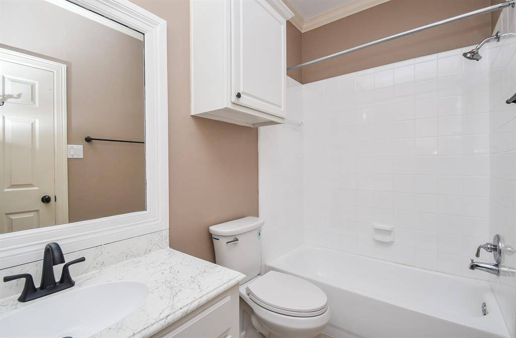 Combined shower/bathtub caters to personal options in a secondary ensuite bathroom.