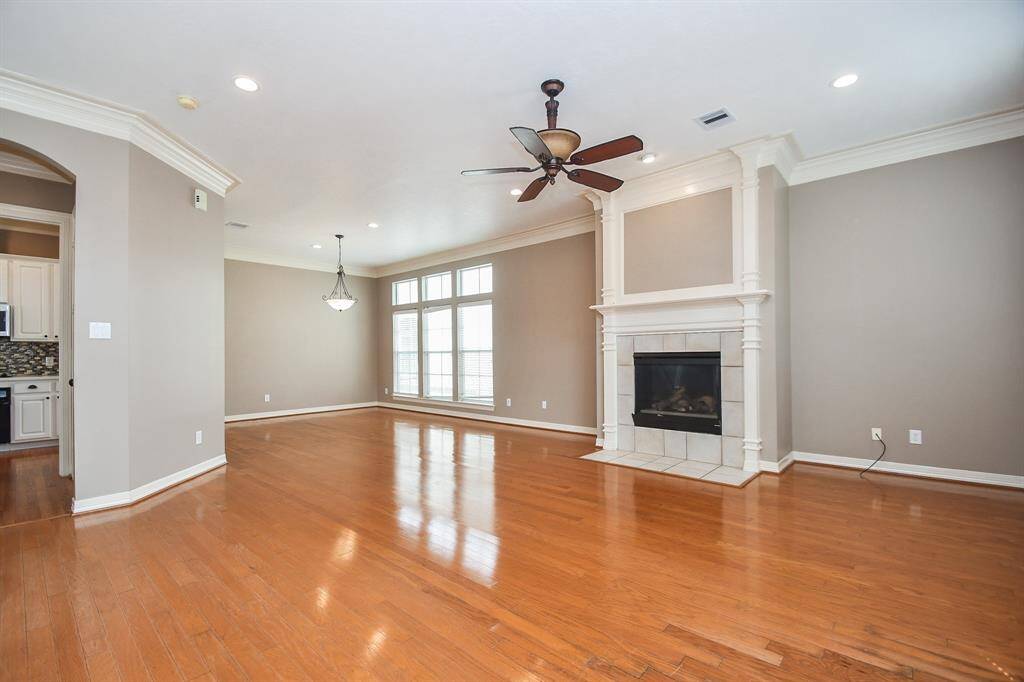 Imagine this huge living space filled with family and friends at holiday time, gathered around a glowing fire! Up center, under the chandelier and in front of a wall of triple windows, is the perfect spot for formal dining, with the kitchen, left.