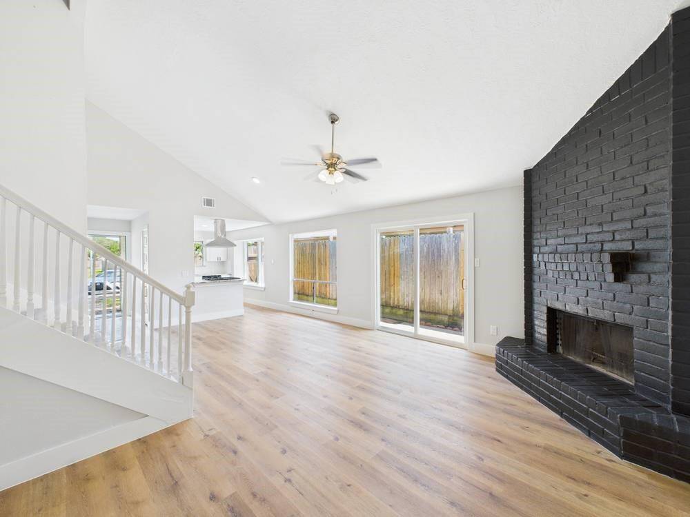 Stunning view of your living and Dining Area! Featuring Tall Ceilings, Plenty of Natural Light, and a GORGEOUS wood burning fireplace!