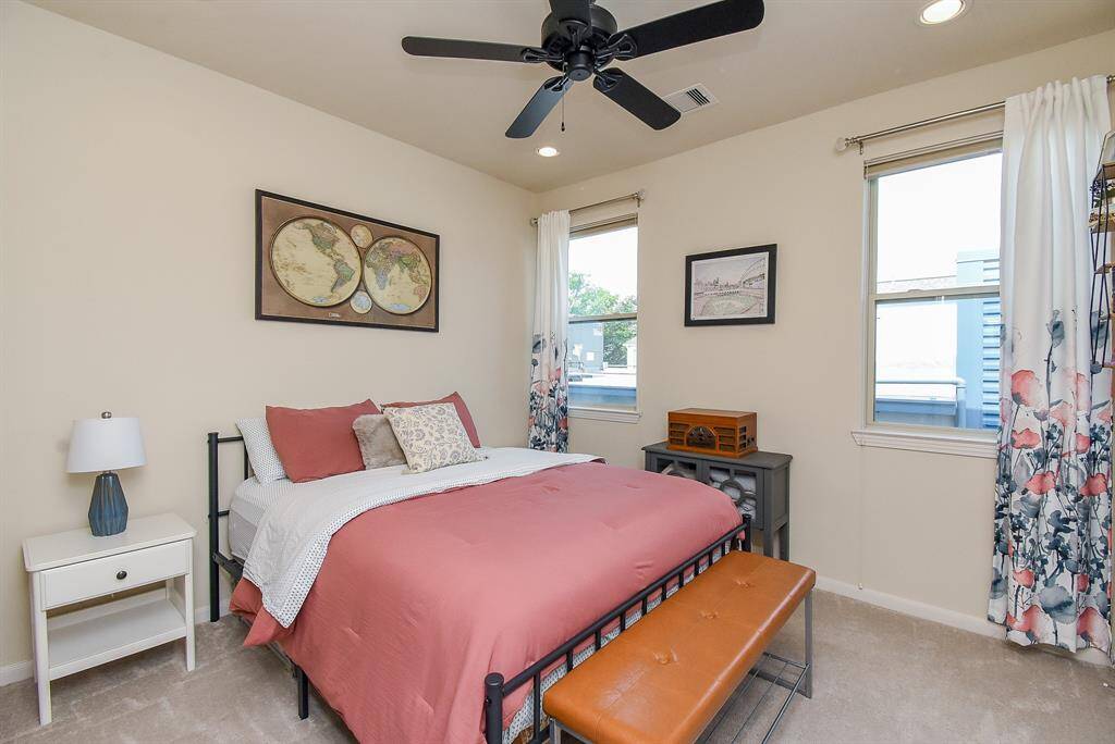 Double windows naturally light this spacious secondary carpeted bedroom.
