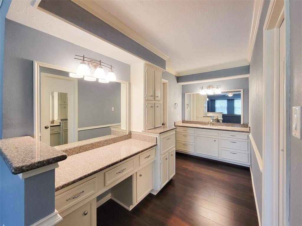 Fresh and inviting, this primary bathroom boasts stunning granite surfaces and sleek white cabinetry for a timeless look