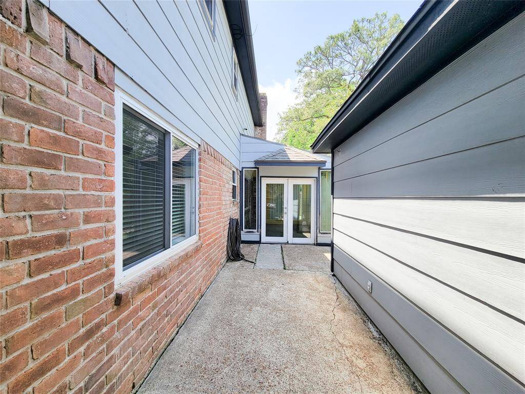 Freshly updated pathway between the detached garage and house with two access points, great for guests to easily move between the home and backyard without entering the house
