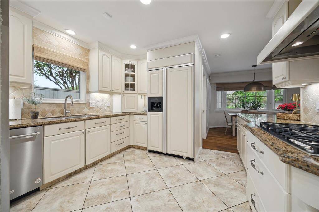 Welcome to the kitchen! Ample storage for the home chef, including large drawers under the gas cooktop for pots and pans, two appliance garages, and a built-in pantry wall (not pictured).