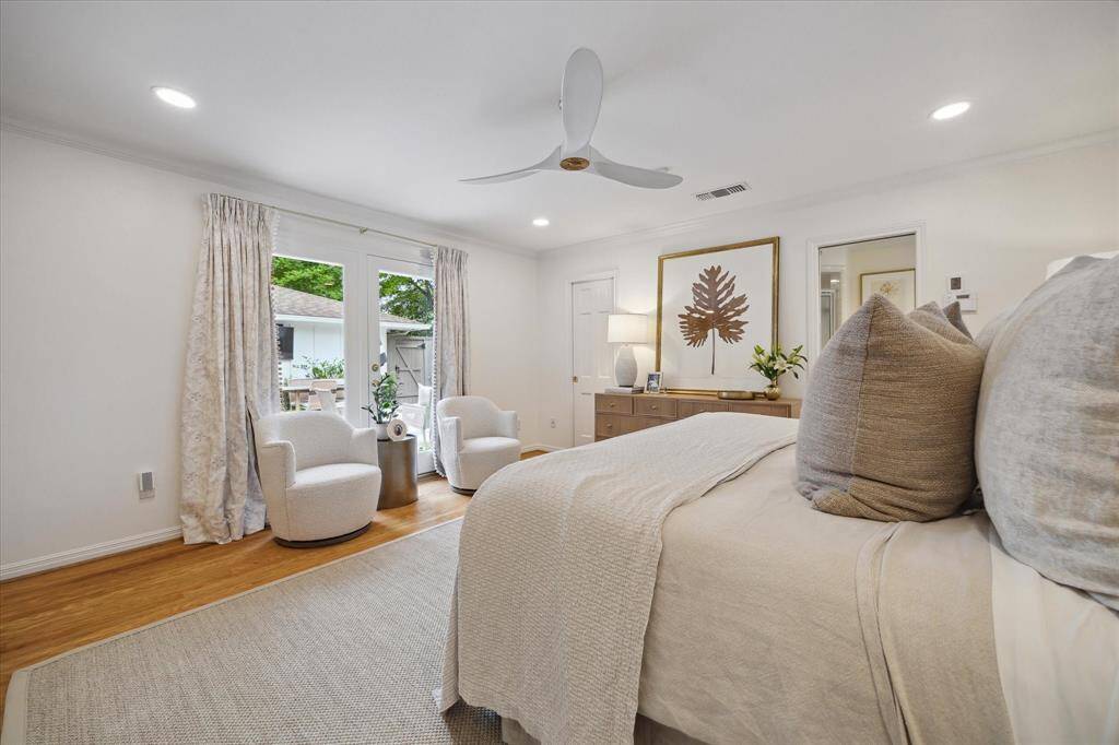 Welcome to the primary bedroom, which features a full-sized window and door overlooking the back patio, not one, but two walk-in closets, and a primary bathroom with a full shower and two sinks.