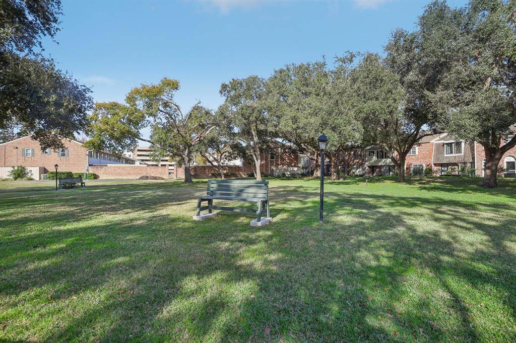 Green space with picnic tables and a grill.