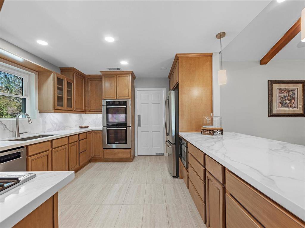 Experience culinary elegance in this modern kitchen featuring sleek quartz countertops.