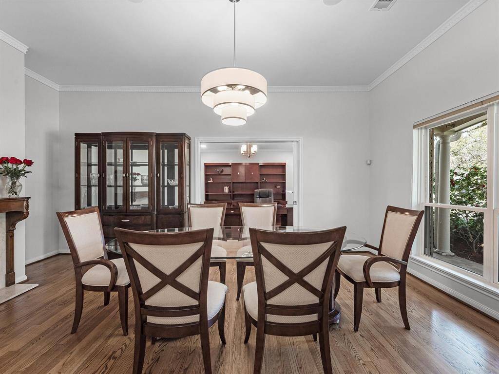 Elegant formal dining room with stunning views of lush front yard trees.