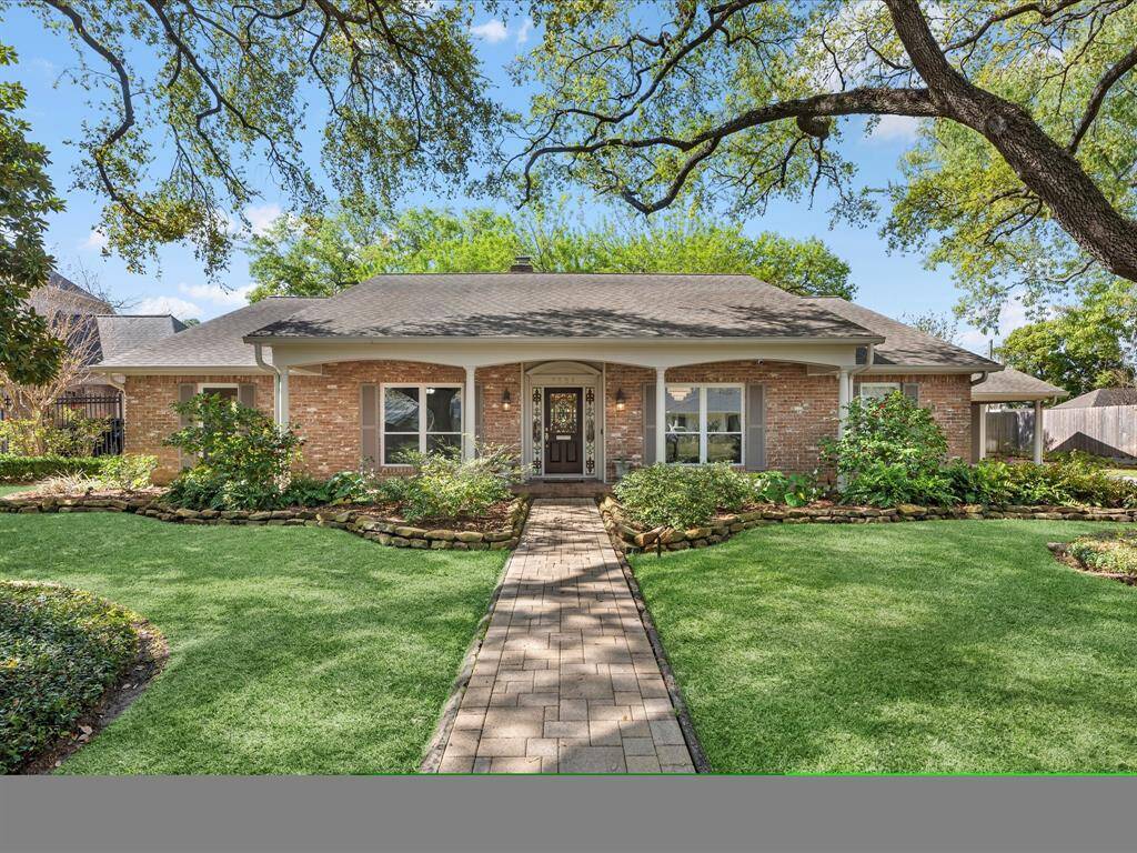 Charming view of your future home, beautifully framed by lush greenery and a welcoming path.