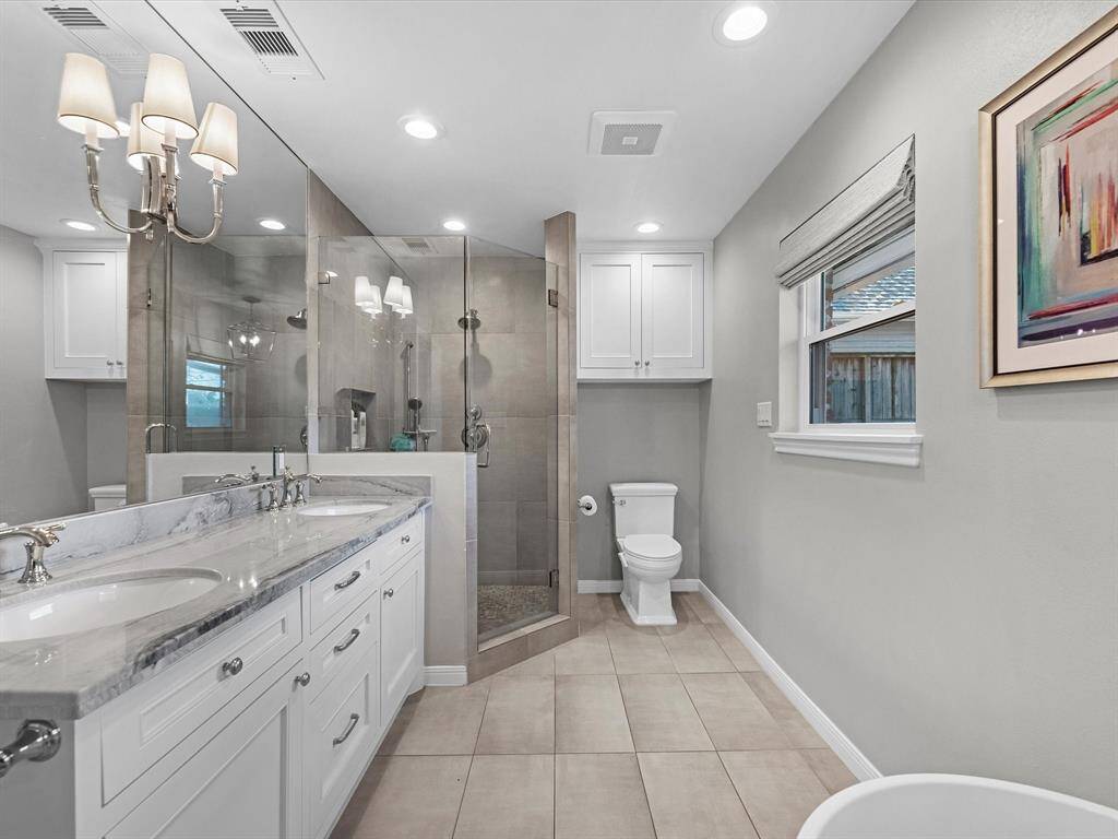 Explore the elegant primary bathroom featuring a spacious walk-in shower for a touch of luxury.