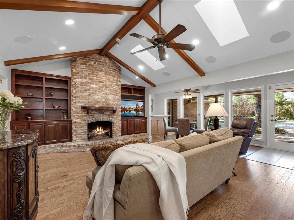 Cozy up by the gas log fireplace, framed by elegant built-in cabinets for added style and storage.
