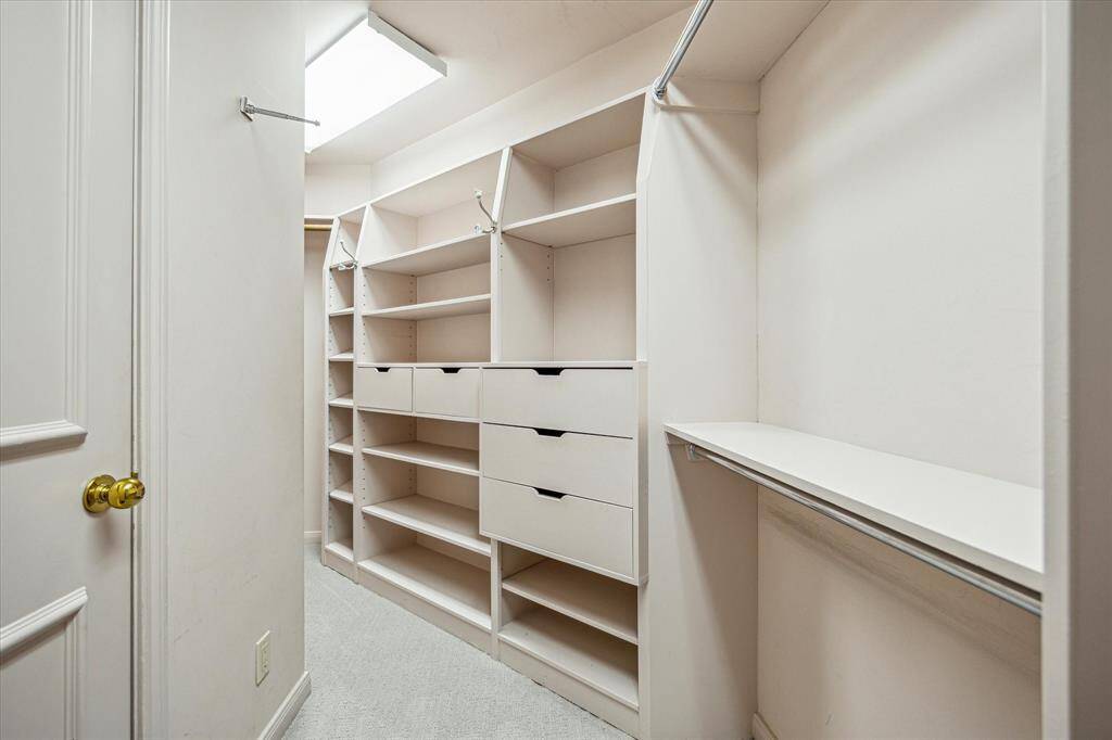 Sitting room in Primary bath with extensive built-ins and sit down vanity.