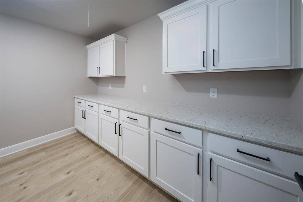 The upstairs utility room has plenty of cabinets for storage and lots of counter space for folding clothes.