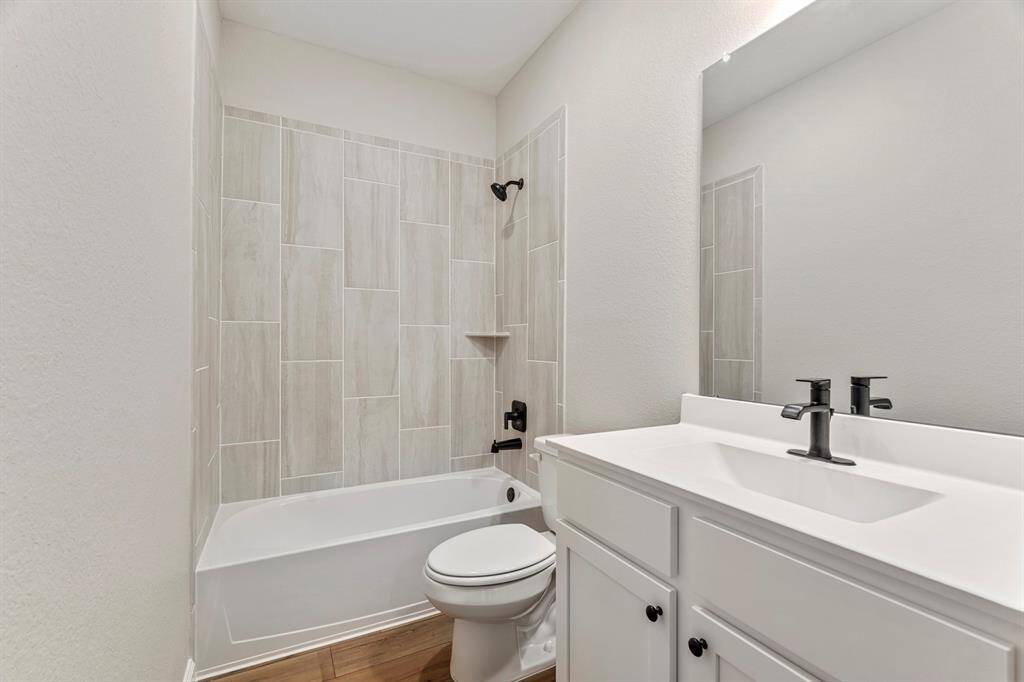 The secondary bathroom has a large tub and shower combo, which is perfect for relaxing in a hot bath or taking a refreshing shower. It also has a large vanity and sink, which provides ample storage space for toiletries and other personal items.