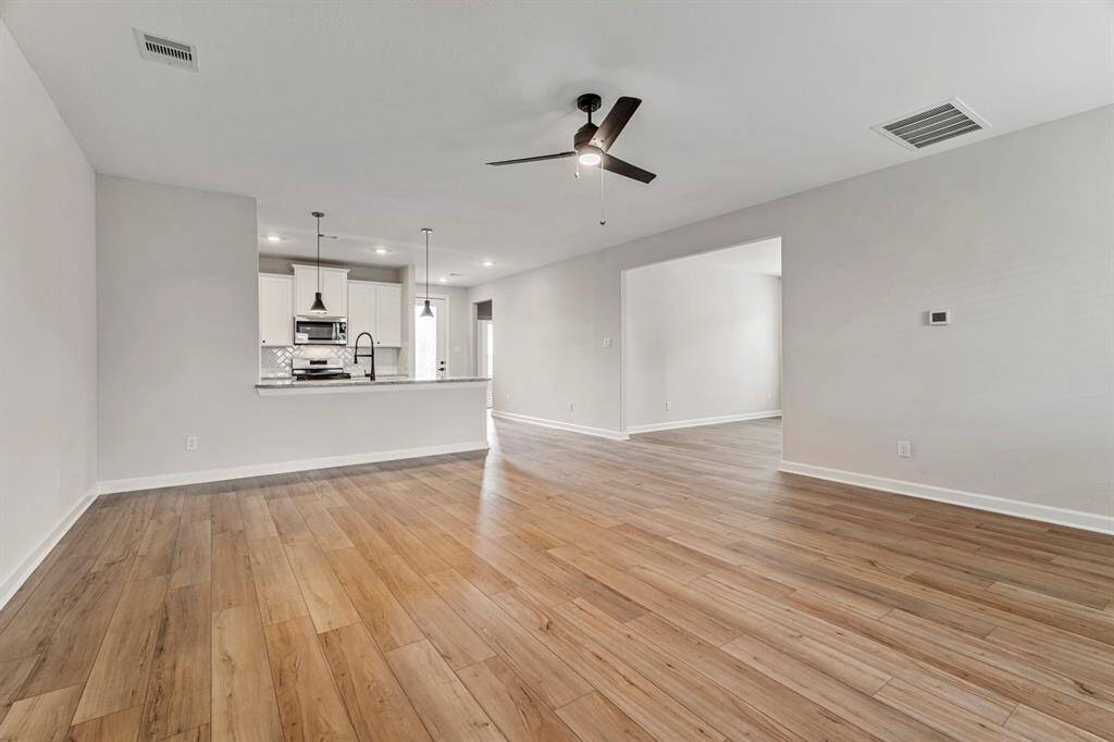 The living area features vinyl plank flooring that exudes warmth and character, complemented by large windows that provide spectacular views of the outdoors. With its open layout, the space offers endless possibilities for relaxation, and entertainment.