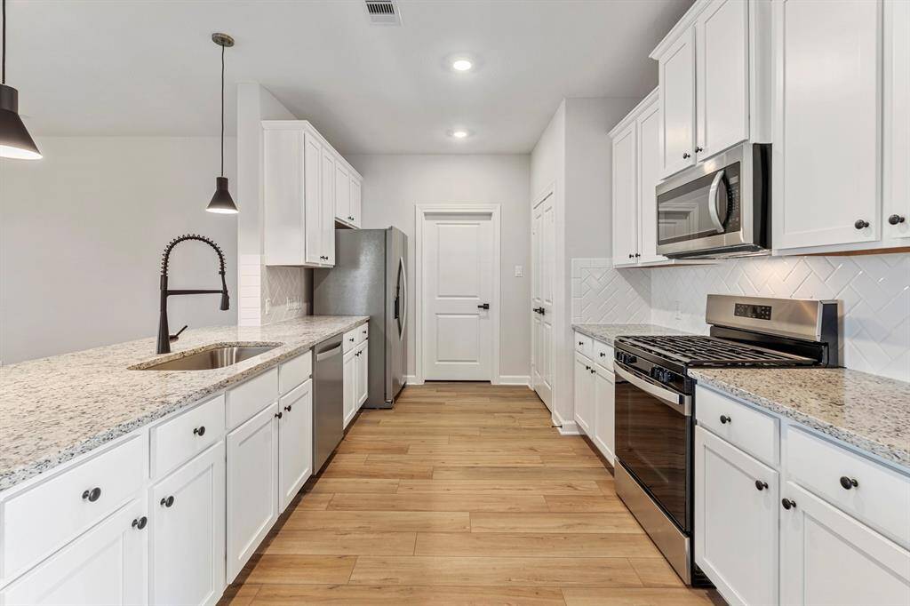 In this kitchen, white cabinets exude a sense of freshness and purity, perfectly paired with the luminous beauty of white granite countertops. The open layout fosters a welcoming atmosphere, inviting conversation and interaction between the kitchen and living area