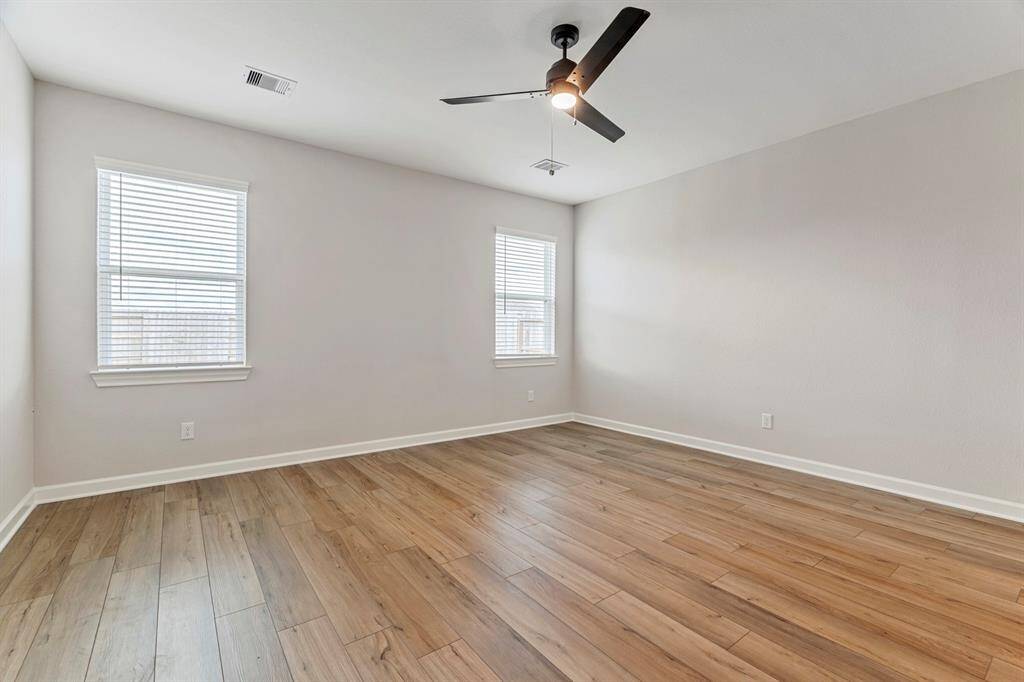 Step into the primary bedroom, where vinyl plank flooring sets the stage for relaxation. Natural light pours in through the windows, creating a warm and relaxing retreat. Tall doors reveals the en-suite bathroom, offering convenience and luxury for the perfect escape.