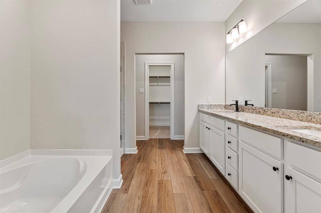 Welcome to the en-suite bathroom, where a sleek granite  vanity and mirror provide a stylish focal point, and a separate tub and shower combo offer the ultimate in comfort and convenience. With its thoughtfully designed layout and luxurious amenities, this private retreat is the epitome of modern luxury