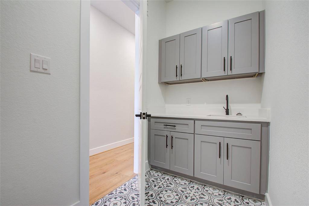 Laundry room with built in wet bar and cabinetry!