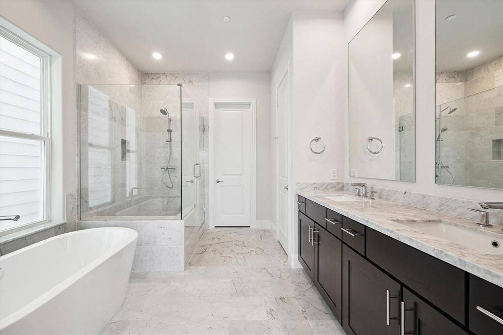 Natural light floods the primary bathroom. This photo is from a previous build with similar finishes.