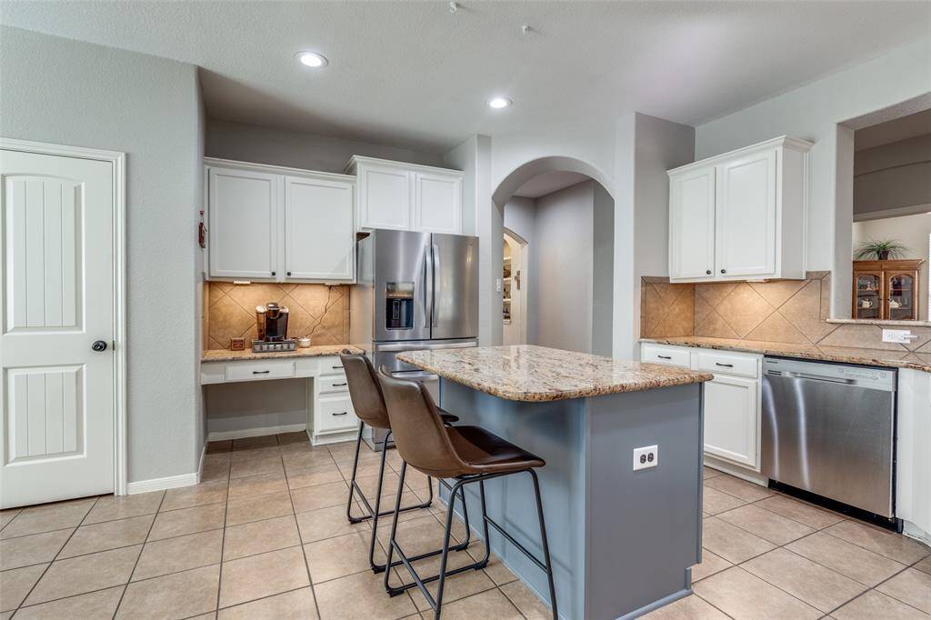 View of kitchen with opening to the front foyer. Door on the left is the pantry.