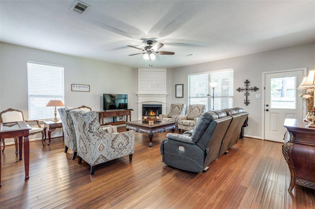 Large main living room with wood burning fireplace as the focal point. Back door on the right.