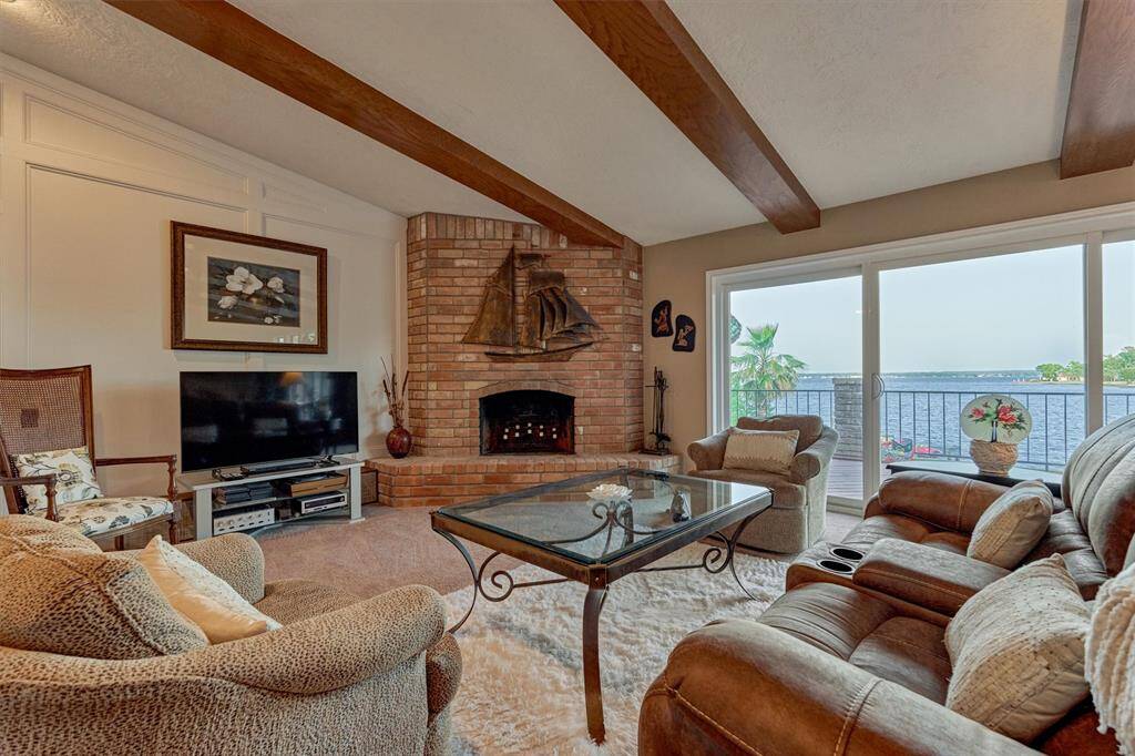 A wood-burning fireplace creates a warm, inviting ambiance on cooler nights, perfectly complemented by unobstructed views of the lake beyond.