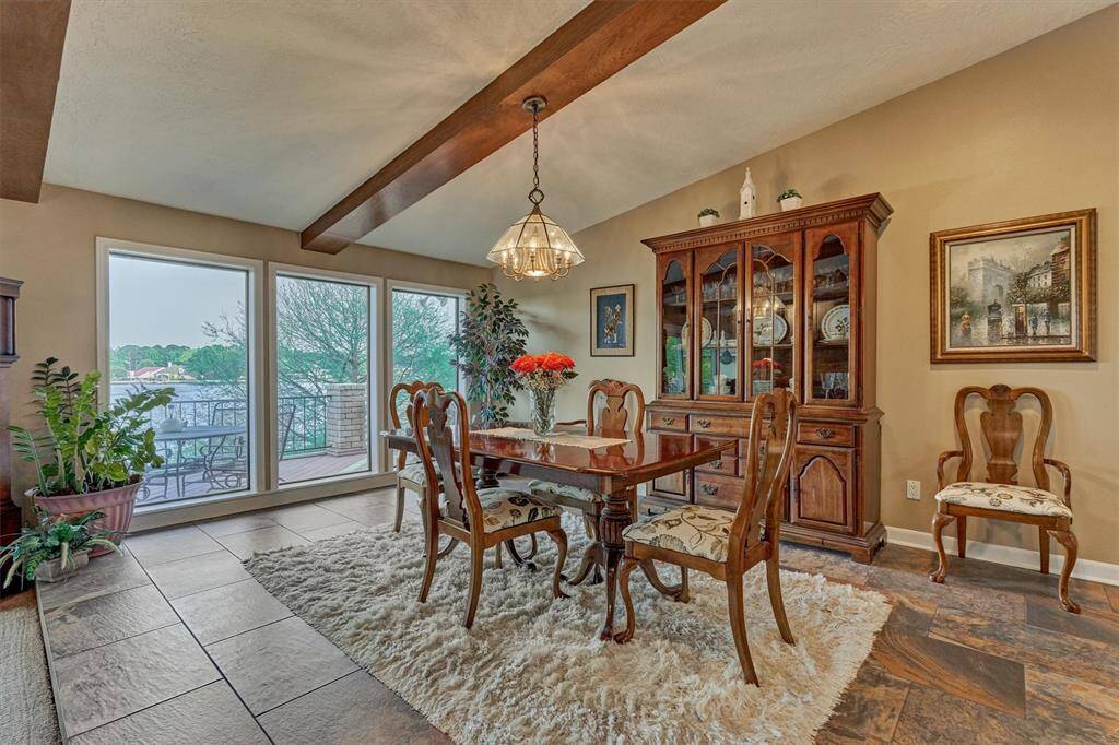 The wood beams carry through into the dining room, tying the spaces together with a warm, cohesive look.Three oversized windows offer picturesque views of the lake.