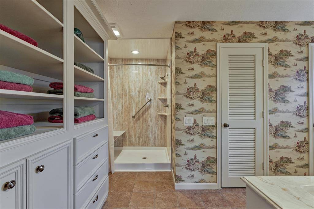 The primary en-suite bath includes built-in storage, dual closets, a walk-in shower, and a separate toilet room for added privacy.