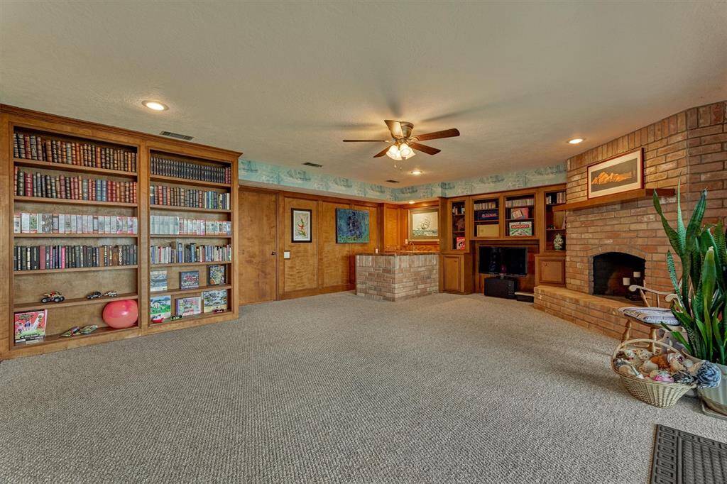 This angle reveals built-in shelving, a convenient wet bar, and a corner fireplace that adds warmth and character to the space.