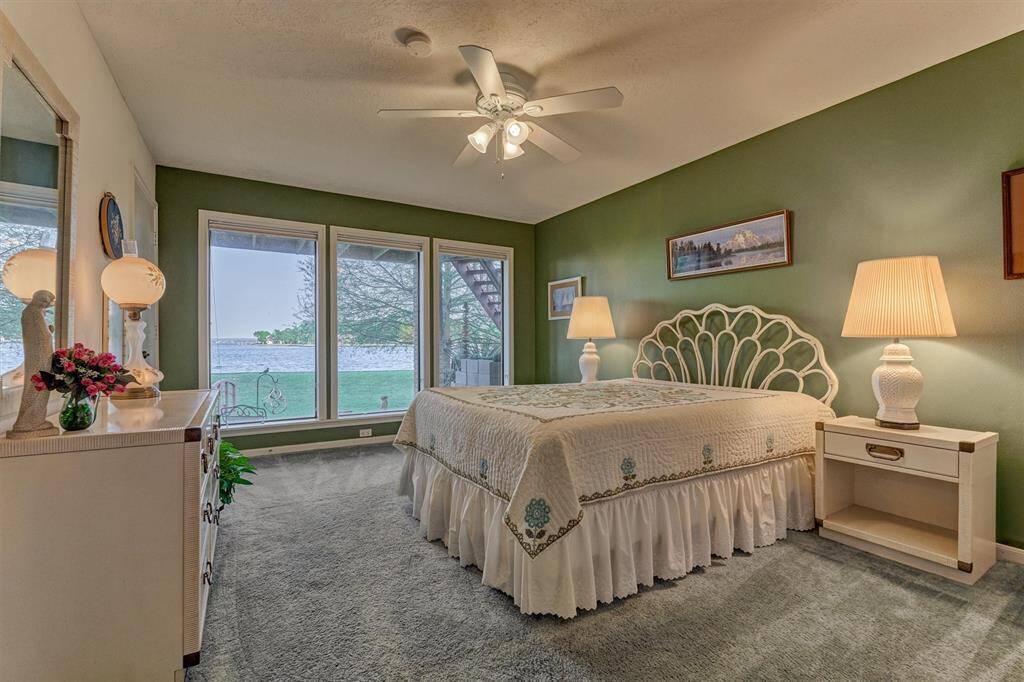 A first floor guest bedroom offers picture windows that frame beautiful views of the lake.
