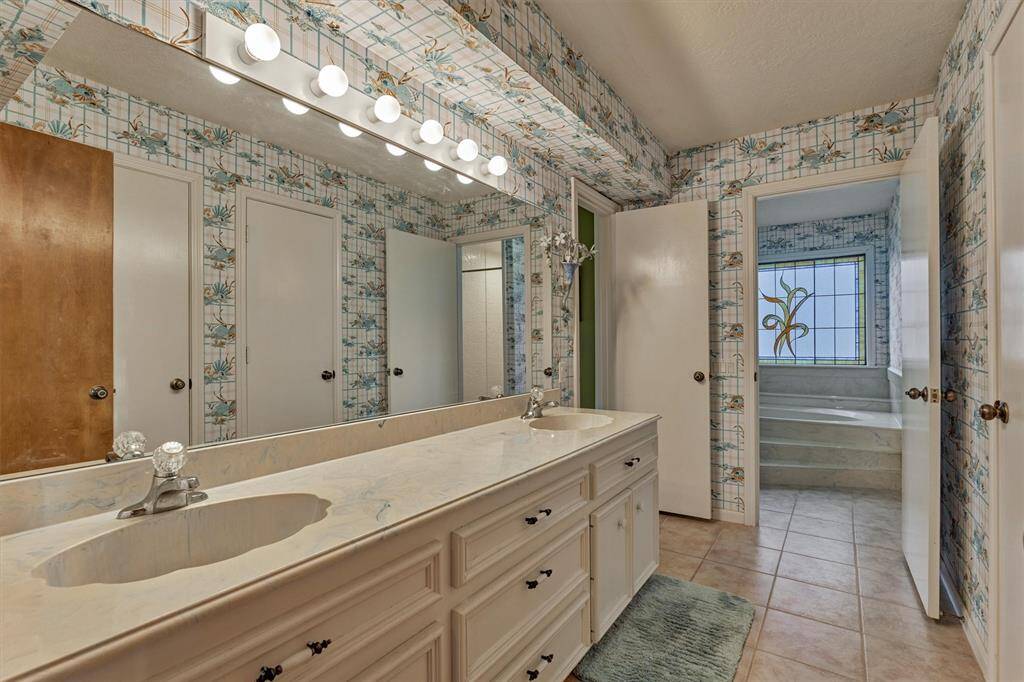 A Hollywood-style bathroom connects to the guest bedroom and offers convenient access from the game room. Featuring double sinks, ample storage, and a separate tub and shower area, this generously sized bathroom is perfect for shared use without sacrificing comfort.