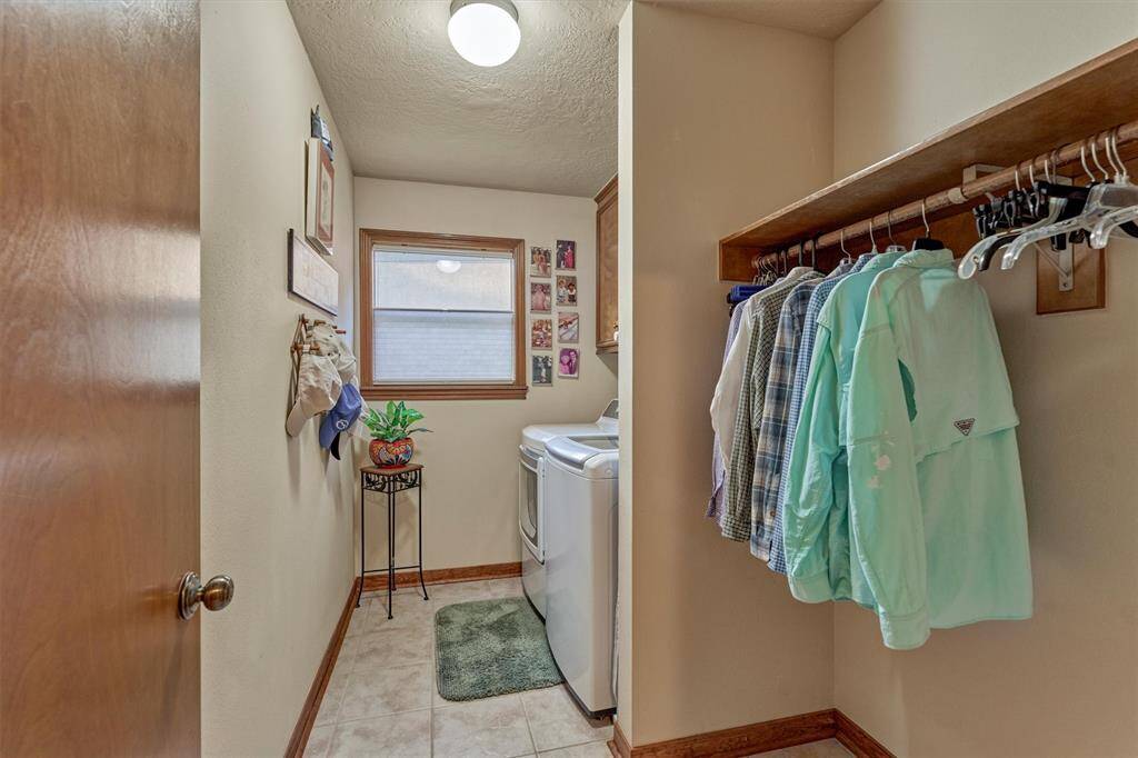 The spacious first-floor laundry room is thoughtfully designed with hanging space and closed storage, combining function and convenience.