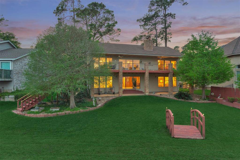 The home is beautifully illuminated at night, creating a warm and inviting presence. This view captures the property as seen from the lake side.