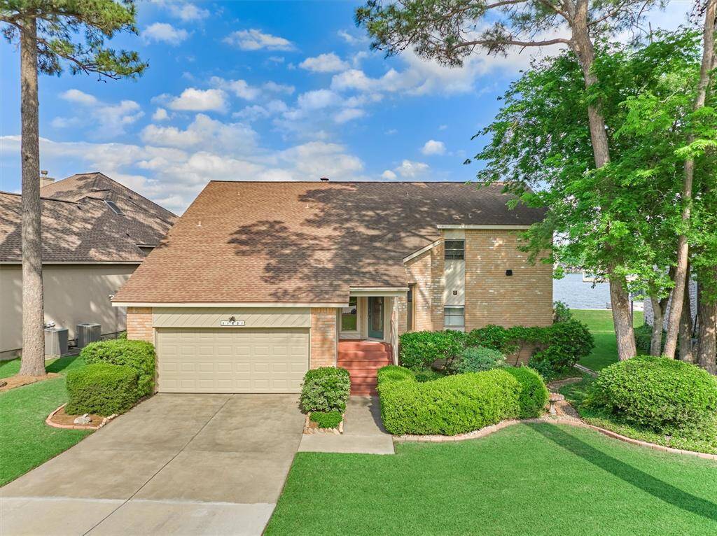 Mature trees and thoughtfully designed landscaping, framed by a classic brick border, enhance the home’s curb appeal and create a warm, welcoming first impression.