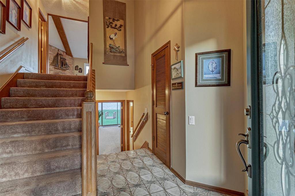 The entry door opens to a foyer with stairs leading to both the first and second levels, with a coat closet just beyond offering additional storage.