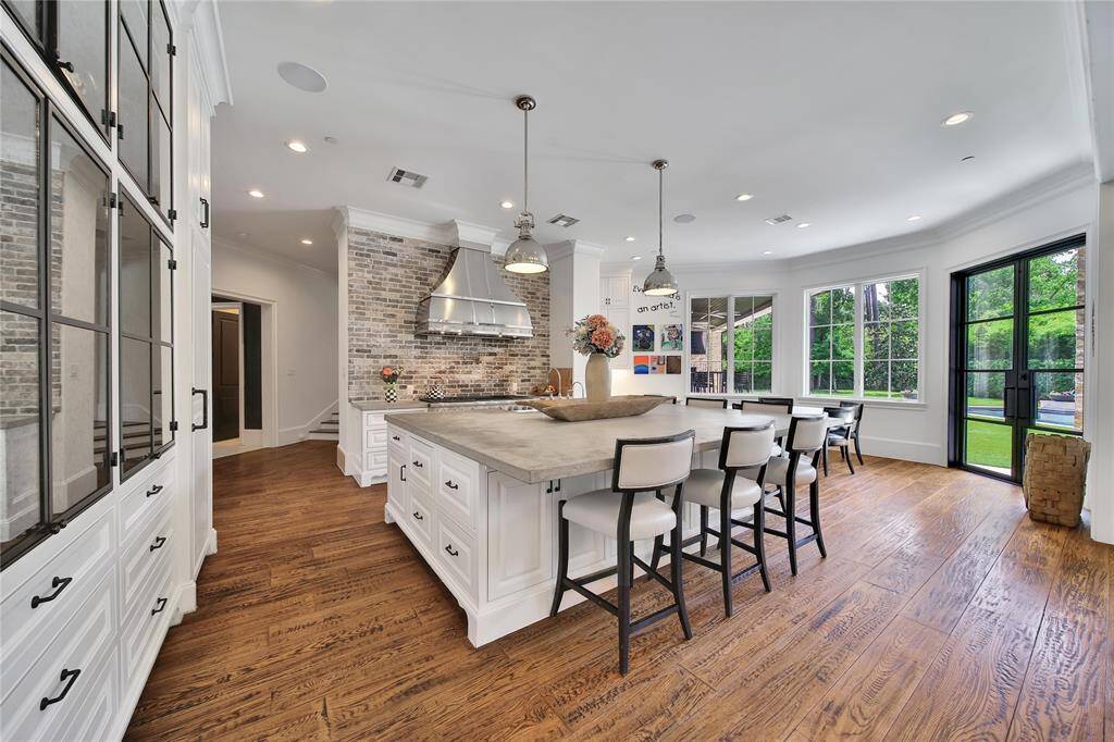 Gourmet kitchen featuring top-of-the-line finishes, custom cabinetry, and premium appliances. Kitchen features two built in refrigerators, island storage, breakfast nook, and gas range.