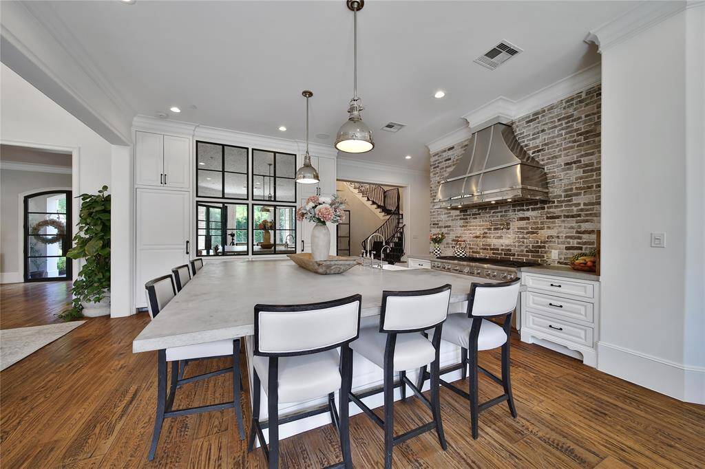 Gourmet kitchen featuring top-of-the-line finishes, custom cabinetry, and premium appliances. Kitchen features two built in refrigerators, island storage, breakfast nook, and gas range.