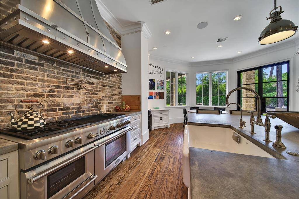 Gourmet kitchen featuring top-of-the-line finishes, custom cabinetry, and premium appliances. Kitchen features two built in refrigerators, island storage, breakfast nook, and gas range.