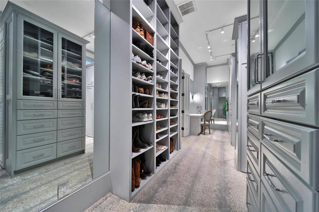 Spacious primary closet with custom shelving, vanity area, and the added convenience of an in-room washer and dryer.