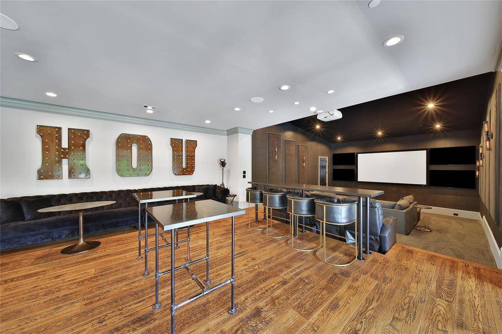 Ultimate entertainer's room featuring a full bar  TVs all around, perfect for hosting unforgettable gatherings.