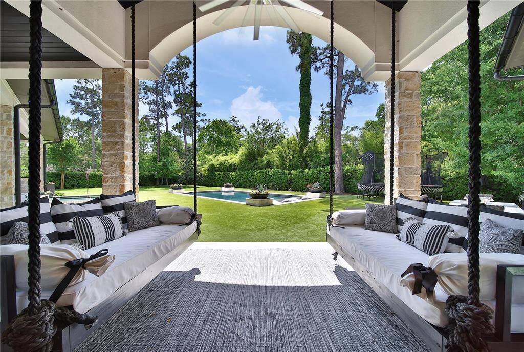 Cozy porch swings perfectly positioned to enjoy the beautiful backyard views.