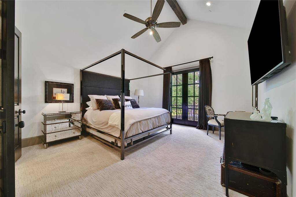 Upstairs primary bedroom featuring vaulted ceilings and ensuite bathroom.