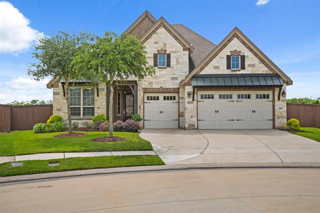 This beautiful home features a charming stone facade with brick accents and a welcoming arched entryway. It includes a spacious three-car garage and manicured landscaping, creating a perfect blend of elegance and functionality.