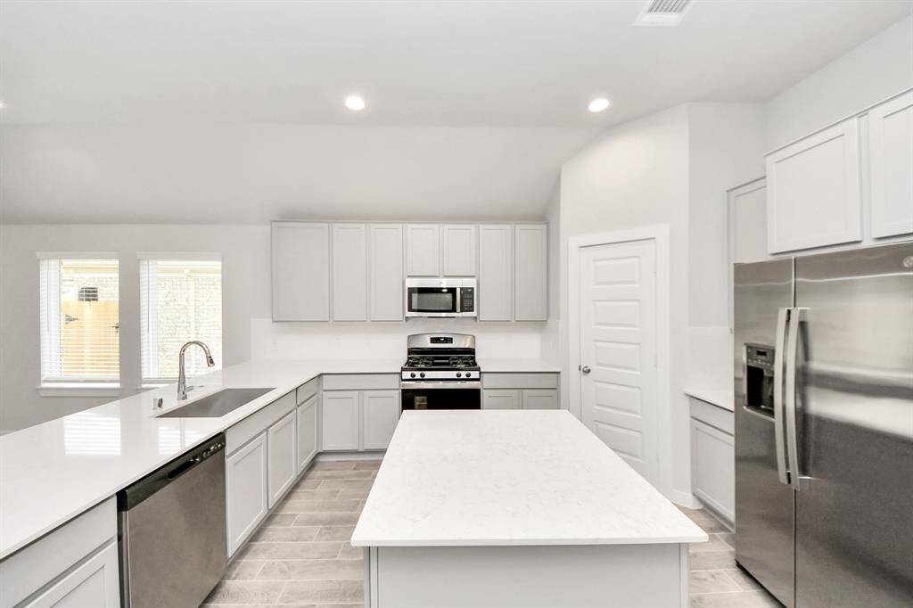 The kitchen is a culinary haven, featuring granite countertops, a tile backsplash, stainlesssteel appliances, and 42” upper cabinets. Sample photo of completed home with similar floor plan. Actual colors and selections may vary.