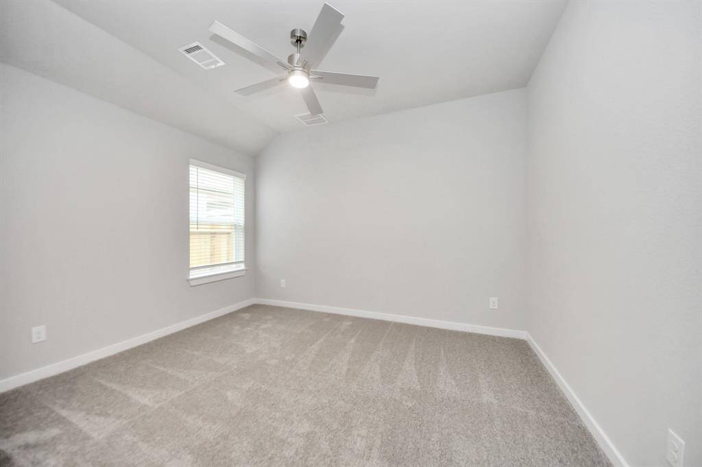 Secondary bedroom features plush carpeting, large windows that let in plenty of naturallight, bright paint, and spacious closets. Sample photo of completed home with similar floor plan. Actual colors and selections may vary.