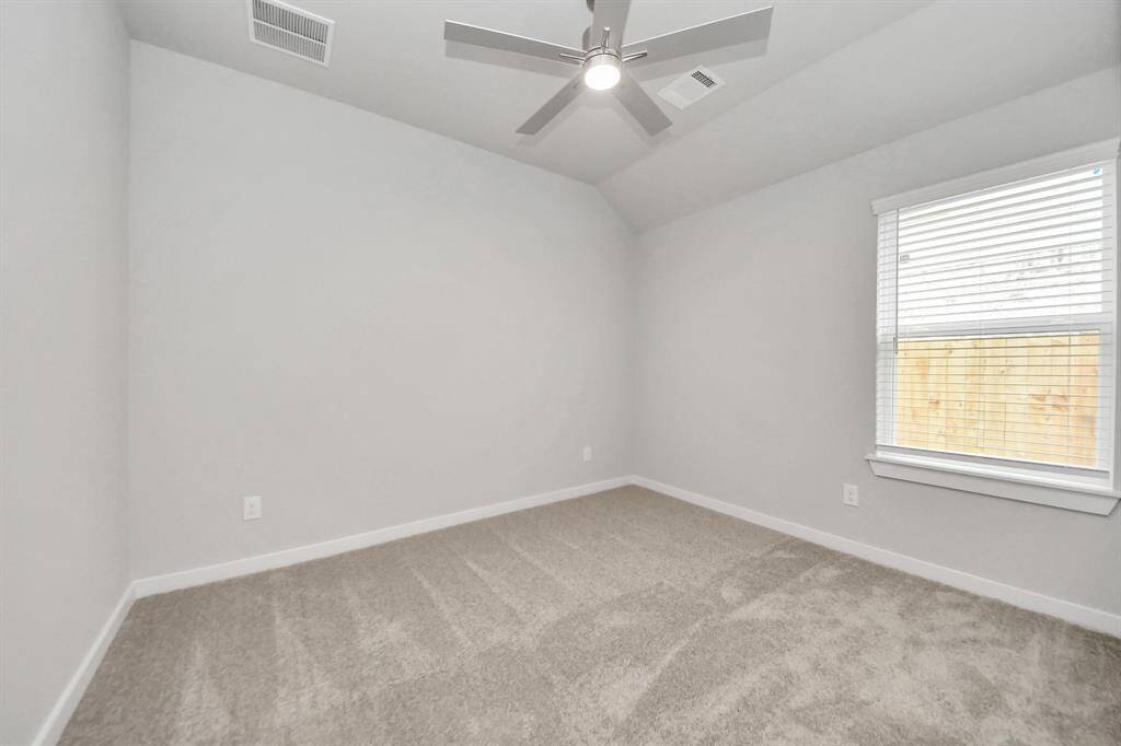 Secondary bedroom features plush carpeting, large windows that let in plenty of naturallight, bright paint, and spacious closets. Sample photo of completed home with similar floor plan. Actual colors and selections may vary.